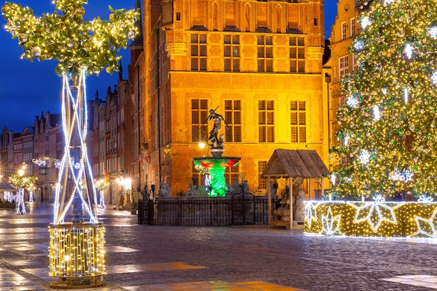 Weihnachtslange Marktstraße mit Neptunbrunnen bei Nacht in der Altstadt von Danzig