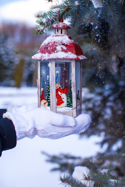 Weihnachtslaterne auf Tannenzweig am Schneewintertag