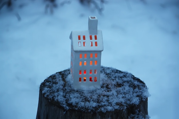 Weihnachtslaterne mit brennender Kerze auf Winternaturhintergrund.