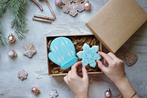 Weihnachtslebkuchen in Glasur in Form, verpackt in einer Bastelbox für die Lieferung nach Hause. Konzept für die Lebensmittellieferung des neuen Jahres.