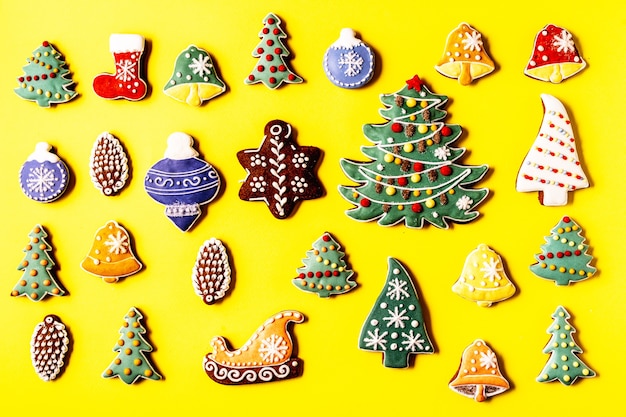 Weihnachtslebkuchen isoliert auf gelbem Hintergrund. Tannenform. Flach legen