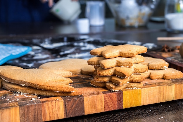 Weihnachtslebkuchenplätzchen auf einem hölzernen Schneidebrett