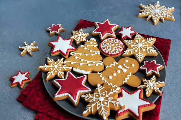 Weihnachtslebkuchenplätzchen auf Teller mit rotem Taschentuch.