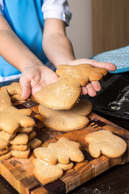 Weihnachtslebkuchenplätzchen und Kinderhände.