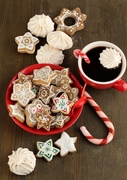 Weihnachtsleckereien auf Teller und Tasse Kaffee auf Holztisch Nahaufnahme