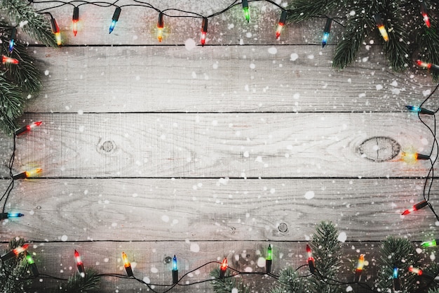 Foto weihnachtslichtbirne und tannenzweig und schneeflocke auf rustikalem holztisch