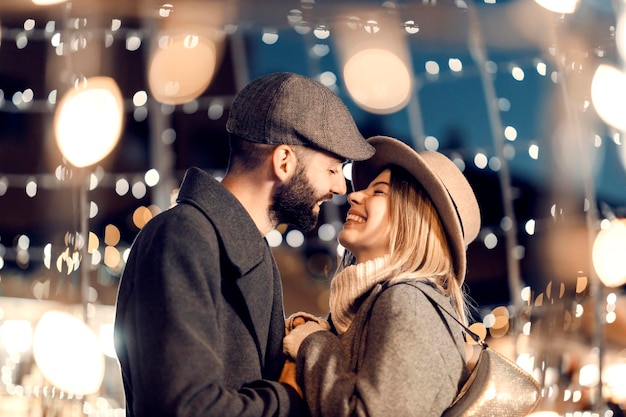 Weihnachtsliebhaber küssen sich am Silvesterabend im Freien