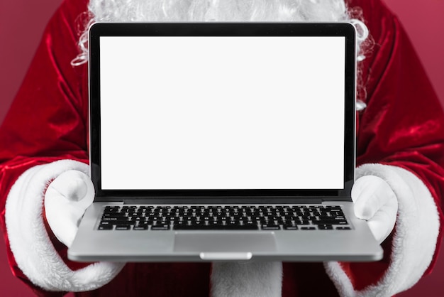 Weihnachtsmann, der Laptop in den Händen hält