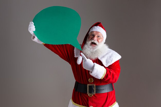 Foto weihnachtsmann, der leeren textballon hält.