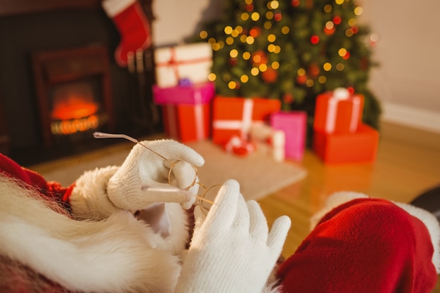 Weihnachtsmann, der seine Gläser anhält