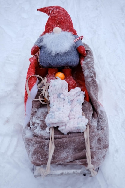 Weihnachtsmann-Gnome auf Schlitten mit Mandarine und Fäustlingen Frohe Weihnachten und ein gutes neues Jahr