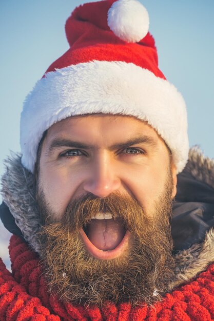 Weihnachtsmann-Hipster-Gesicht in rotem Hut und Schal Weihnachtsmann mit langem Bart und Schnurrbart im Gesicht