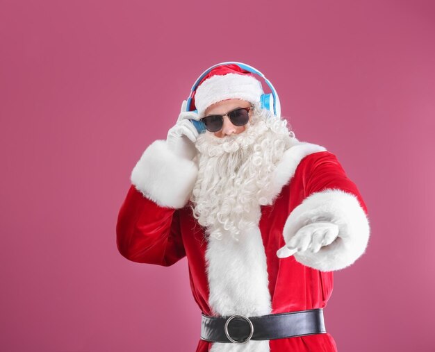 Weihnachtsmann hört Musik auf farbigem Hintergrund