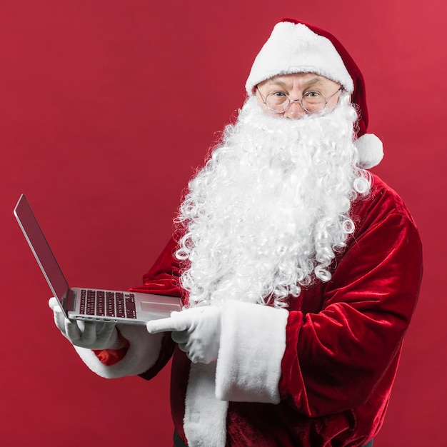 Foto weihnachtsmann in gläsern mit laptop