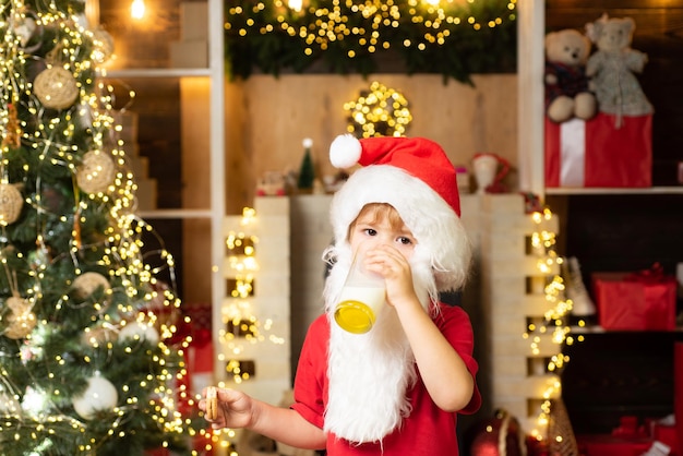 Weihnachtsmann isst Kekse und trinkt Milch an Heiligabend kleiner Weihnachtsmann, der Kekse und Glas pflückt ...