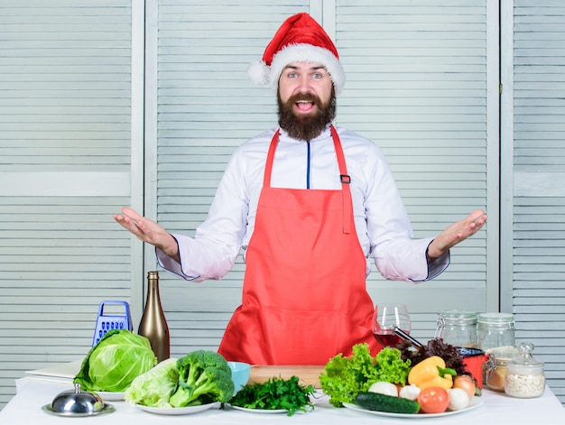 Weihnachtsmann kocht Vegetarischer Salat mit Gemüse Diät Bio-Lebensmittel Glücklicher bärtiger Mann Kochrezept Gesundes Essen kochen Reifer Hipster mit Bart Küche kulinarisch Vitamin Bist du bereit