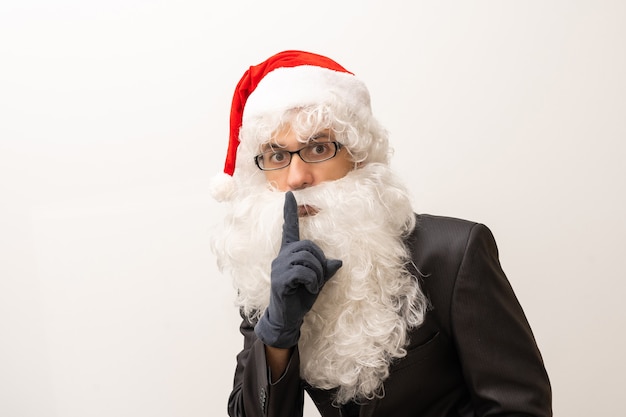 Weihnachtsmann mit Finger auf den Lippen auf weißem Hintergrund