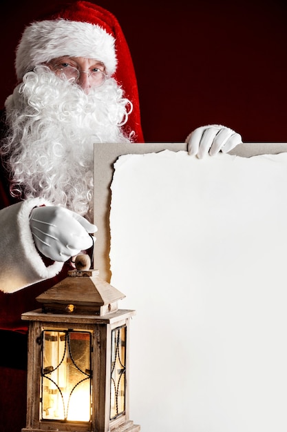 Weihnachtsmann mit Vintage-glühender Laterne und großer leerer Karte