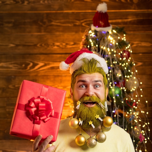 Weihnachtsmann posiert auf Vintage-Holzhintergrund Frohes neues Jahr Wintergefühl Bärtiger Mann, der Spaß in der Nähe hat