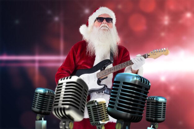 Foto weihnachtsmann spielt gitarre mit sonnenbrille gegen lichtdesign auf rosa hintergrund