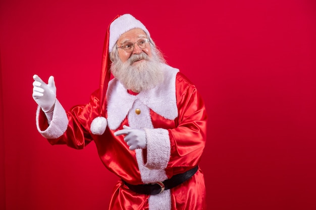 Weihnachtsmann tanzt glücklich auf rotem Hintergrund