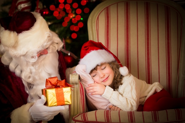 Weihnachtsmann und Kind zu Hause. Weihnachtsgeschenk. Familienurlaubskonzept