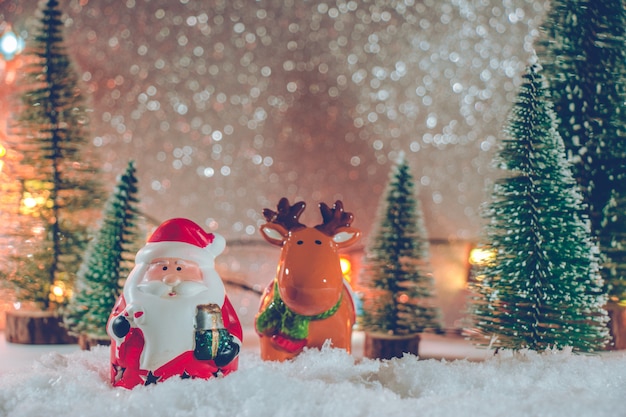 Foto weihnachtsmann und ren stehen im stapel des schnees nachts stilles mit weihnachtsbaum und verzierung