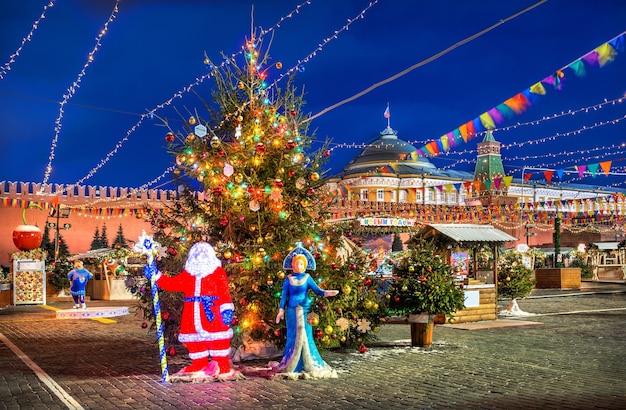 Weihnachtsmann und Schneewittchen am Neujahrsbaum auf dem Roten Platz in Moskau in einer Winternacht