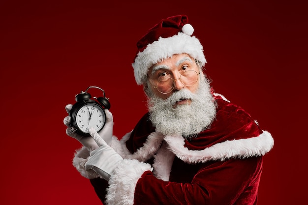 Weihnachtsmann zeigt auf die Uhr