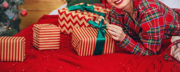 Weihnachtsmorgen, Mädchen mit Geschenken in ihren Händen. Tiefenschärfe.