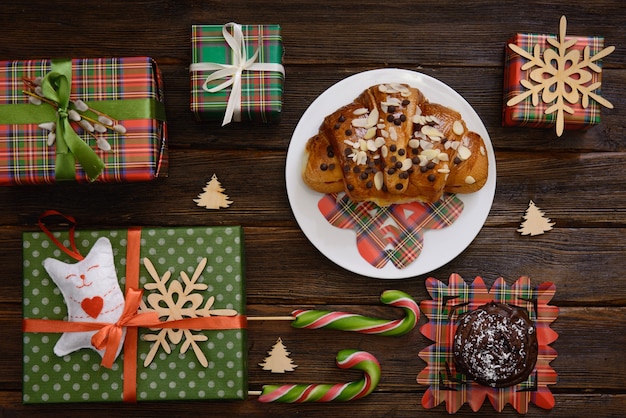 Weihnachtsmorgen Tisch mit Croissant, Süßigkeiten und Geschenken