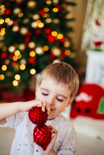 Weihnachtsmorgenjunge packt Geschenke aus