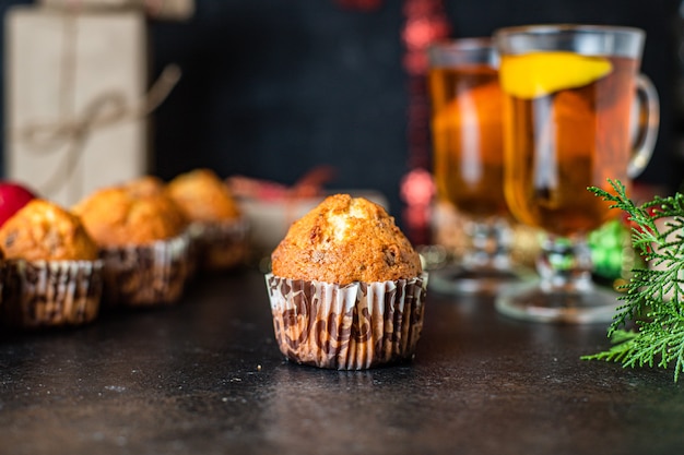 Weihnachtsmuffins mit Dekorationen auf schwarzem Tisch