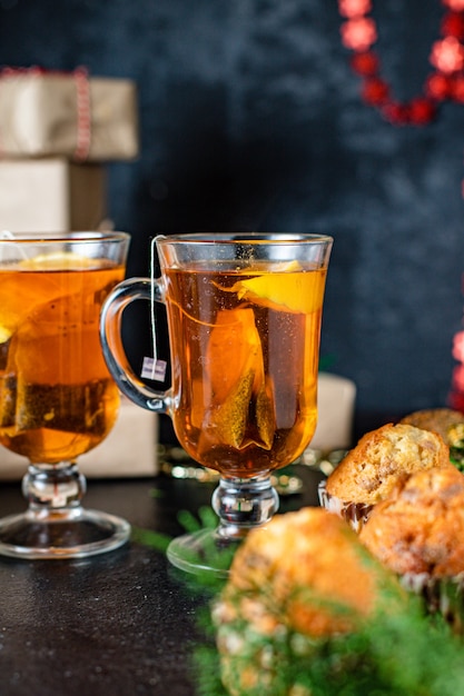 Weihnachtsmuffins mit Dekorationen auf schwarzem Tisch