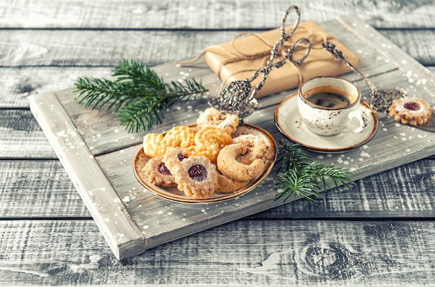 Weihnachtsplätzchen mit Kaffee und Dekoration. Vintage getöntes Bild