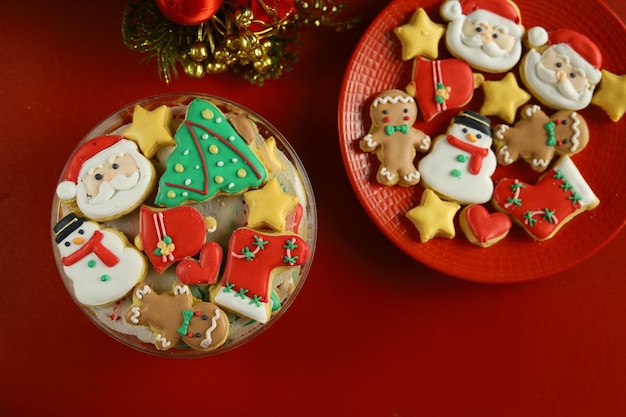 Weihnachtsplätzchen mit königlicher Zuckerglasurdekoration mit rotem Hintergrund