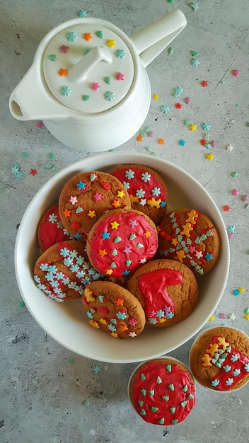 Weihnachtsplätzchen und eine weiße Teekanne auf hellem Hintergrund