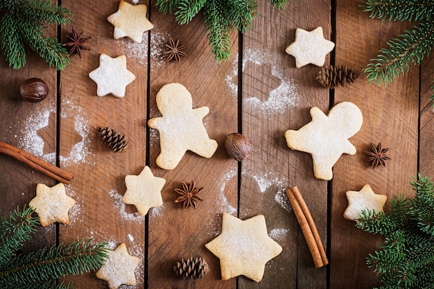 Weihnachtsplätzchen und -lametta auf einem Holztisch