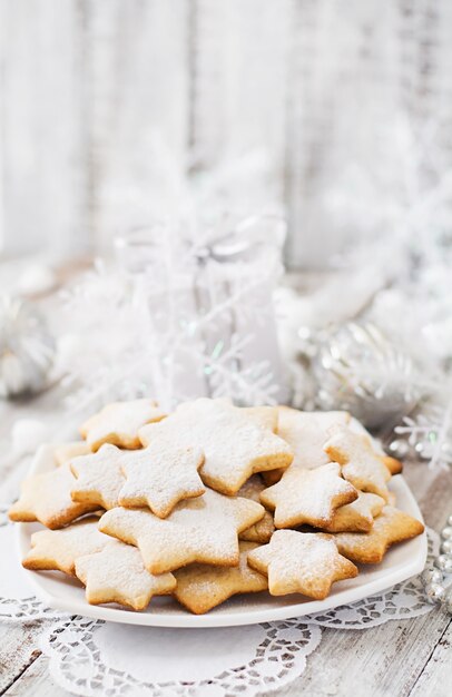 Weihnachtsplätzchen und -lametta auf einem Holztisch