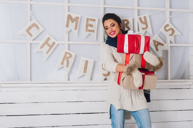 Weihnachtsporträt eines Mädchens mit Geschenk in der Winterkleidung.