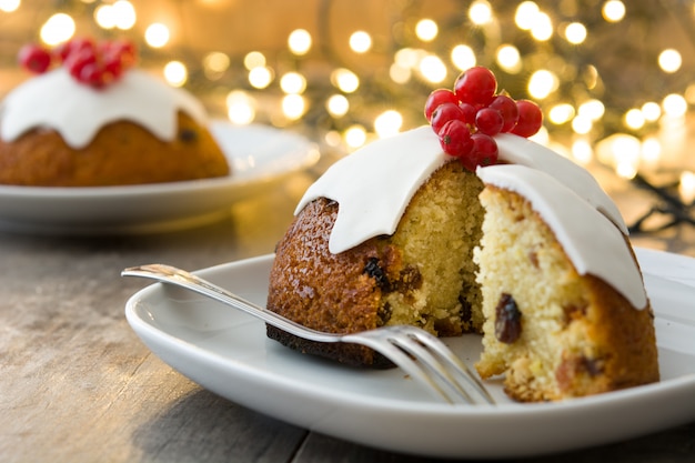 Weihnachtspudding und Weihnachtslicht auf Holztisch