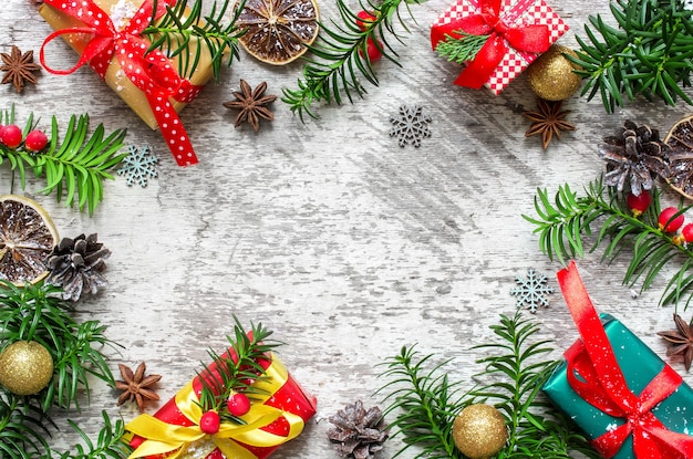 Weihnachtsrahmen aus Tannenzweigen, Geschenkboxen, roten Beeren