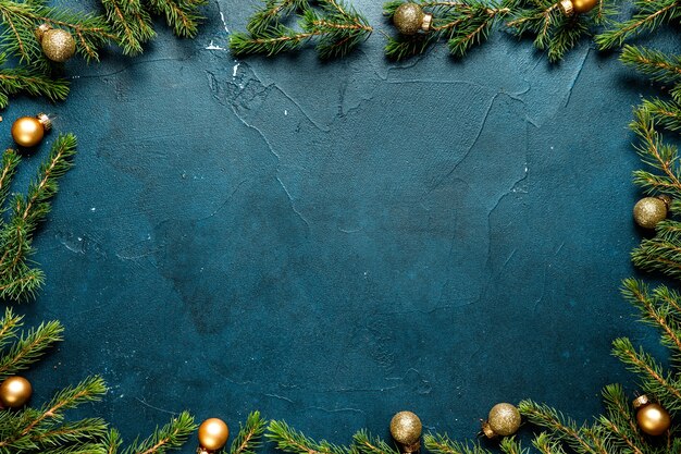 Weihnachtsrahmen aus Weihnachtstannenbaum und Dekorationen auf Minzhintergrund