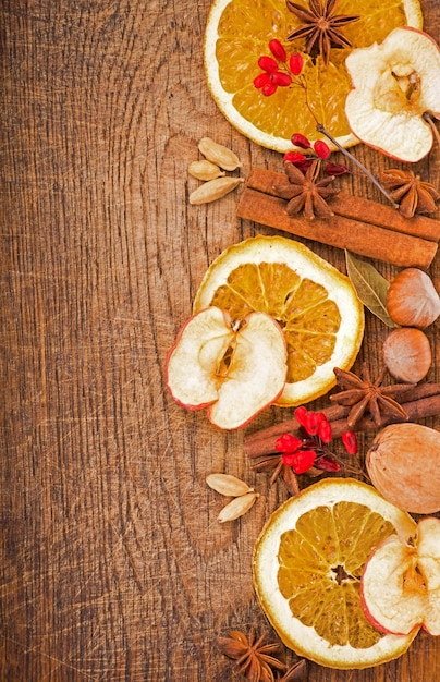 Weihnachtsrahmen Gewürze und getrocknete Orangenscheiben auf einem Holztisch