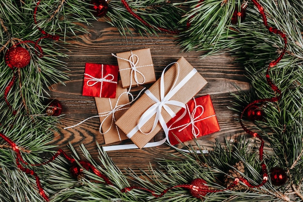 Weihnachtsrahmen mit Geschenken und Dekoration auf Holztisch, flach gelegt