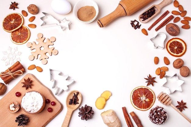 Foto weihnachtsrahmen mit lebkuchen-ausstechformen und zutaten flat-lay-stil