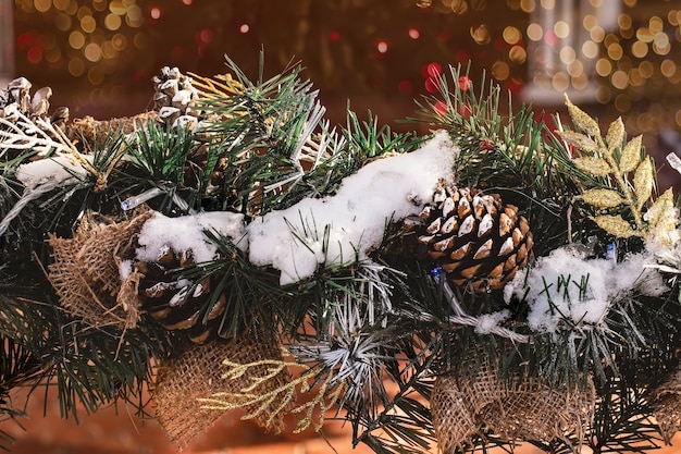 Weihnachtsrahmen von Ästen auf dem Hintergrund von bunten Girlandenlichtern Kopienraum