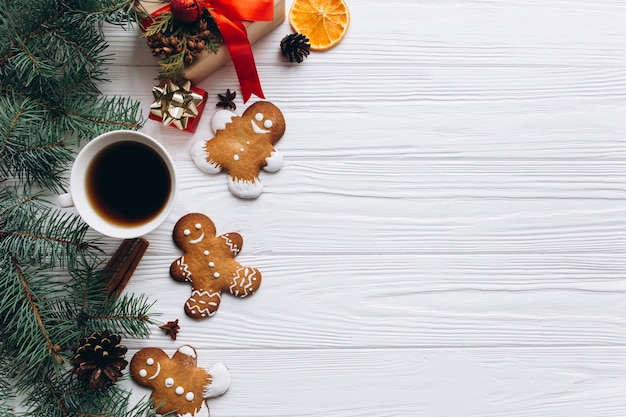 Weihnachtsrand. Lebkuchenplätzchen, -gewürze und -dekorationen auf weißem hölzernem Hintergrund.