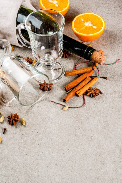 Weihnachtsrezepte der heißen Getränke, Satz Bestandteile für Glühwein: Weinflasche, Glasschalen, Gewürze, Orange, Kopienraum