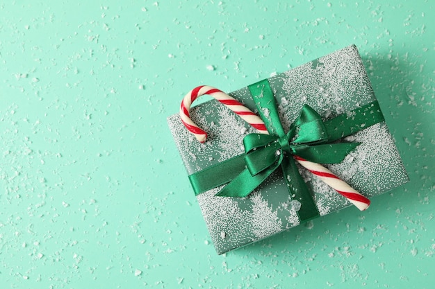 Weihnachtsschachtel mit Zuckerstange auf Minze mit Schnee